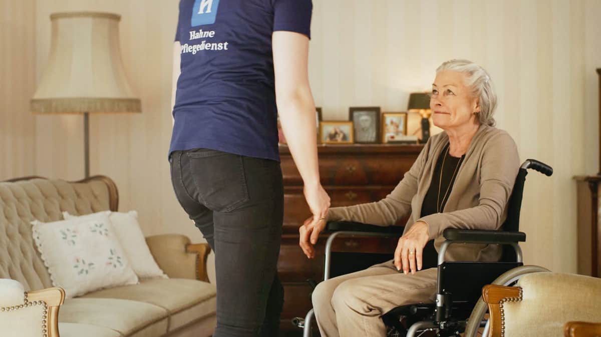 Pflegekraft im Heimservice im Gespräch mit älterer Dame im Rollstuhl, professionelle Betreuung, Seniorenpflege und Unterstützung zu Hause, vertrauenswürdiger Pflegedienst in Deutschland.