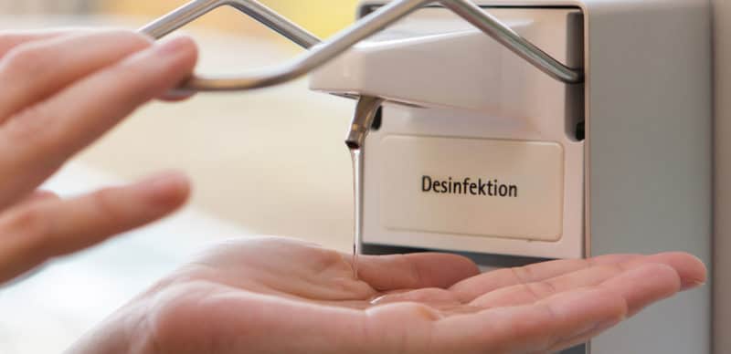 Hand, die Desinfektionsmittel in der Pflege beim Hahne Pflegedienst dispensen - Hygiene, Sauberkeit, Pflegepersonal, professionelle Desinfektion, Gesundheitsschutz.