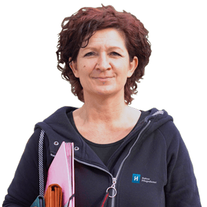 Pflegekraft von Hahne Pflegedienst lächelt freundlich in einem dunklen Hoodie, bereit für hochwertige ambulante Pflege und Betreuung älterer Menschen in ihrer häuslichen Umgebung.
