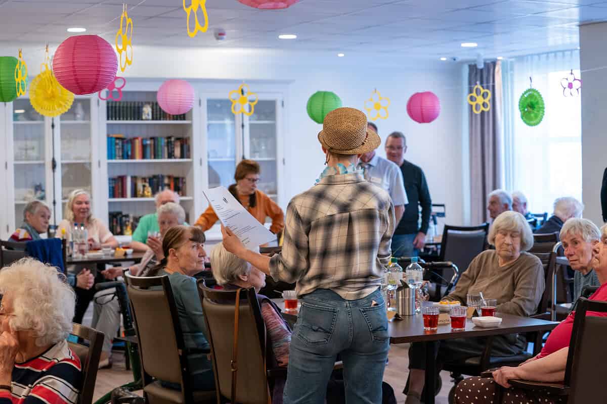 Senioren in Tagespflege bei Hahne Pflegedienst, betreut und aktiv in einem hellen Raum mit bunten Dekorationen, die eine freundliche Atmosphäre schaffen.